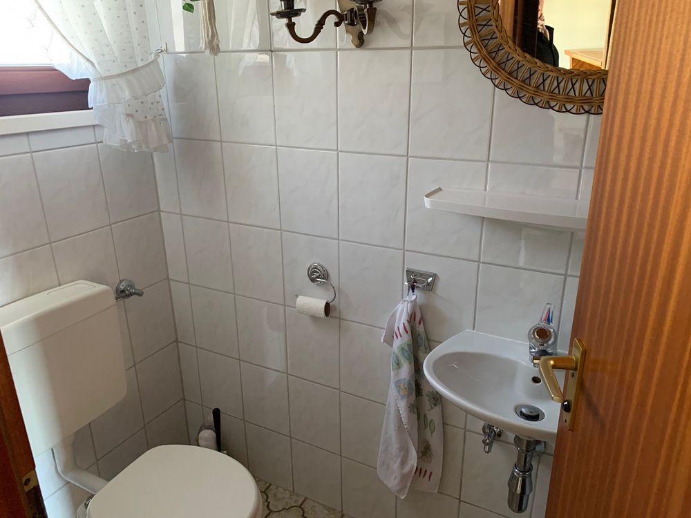 WC vorher: weiße Wandfliesen, kleines Waschbecken